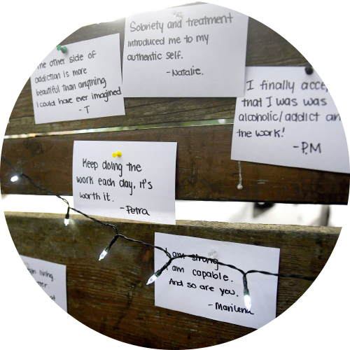 A photograph showing many uplifting notes pined on cards to a fence.
